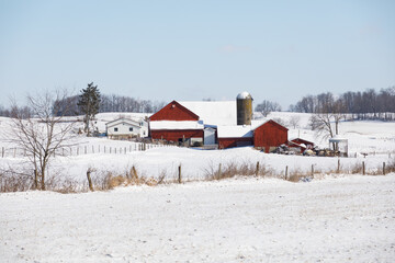 Amish farm with red barns in the snowy countryside | Winter in Holmes County, Ohio