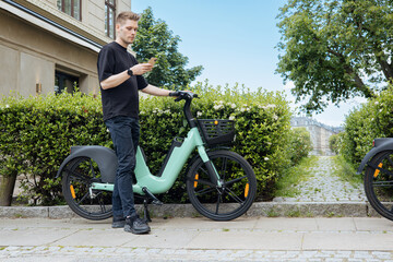 Young man unlocking a bike. Sustainable mobility transport New way of inclusive cities mobility....