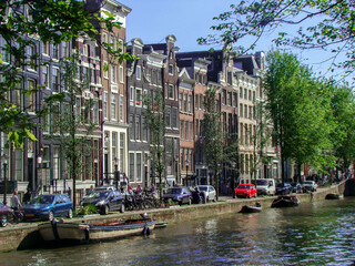 Canal in Amsterdan (Netherlands) a bridge and people in which we can see the arquitecture of amsterdam's house.