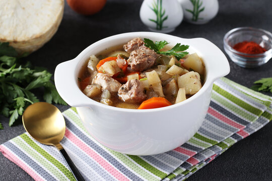 Pichelsteiner, German stew or thick soup with meat and vegetables in white bowl, Close-up