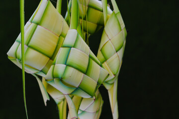 A group of empty Ketupat skin or ketupat pouch with copyspace and green background