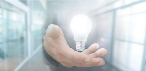 hand with light bulb in business background