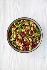 Homemade Three Bean Salad in a Bowl on a white wooden background, top view. Flat lay, overhead, from above.
