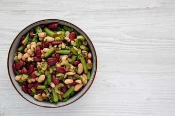 Homemade Three Bean Salad in a Bowl on a white wooden background, top view. Flat lay, overhead, from above. Copy space.