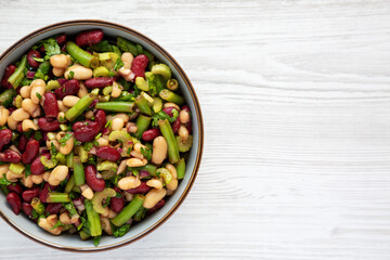 Homemade Three Bean Salad in a Bowl on a white wooden background, top view. Flat lay, overhead, from above. Copy space.