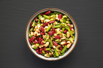 Homemade Three Bean Salad in a Bowl on a black background, top view. Flat lay, overhead, from above.