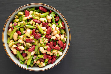 Homemade Three Bean Salad in a Bowl on a black background, top view. Flat lay, overhead, from above. Space for text.