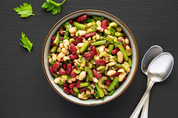 Homemade Three Bean Salad in a Bowl on a black background, top view. Flat lay, overhead, from above.