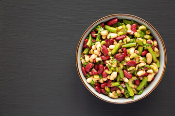 Homemade Three Bean Salad in a Bowl on a black background, top view. Flat lay, overhead, from above. Copy space.