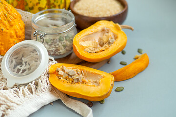 Zero waste healthy food pumpkin, seeds, vegetables, dried fruits close up on blue background. Groceries in textile bags,glass jars. Eco friendly plastic free low waste lifestyle.