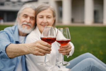 Senior couple holding two glasses with wine in front of themself