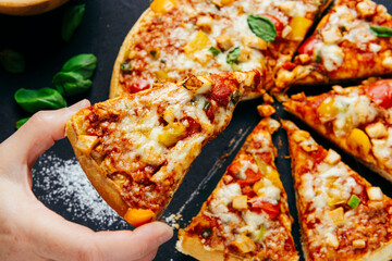 People Hands Taking Slices Of Pizza Margherita. Pizza Margarita and Hands close up over black background.