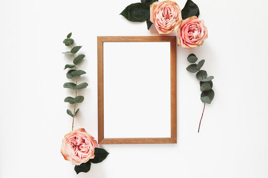 Wood empty frame on white with green eucalyptus branches and flower decor