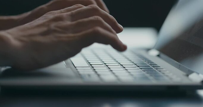 Male hands close up typing text on laptop