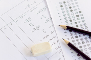 Pencil and eraser on answer sheets or Standardized test form with answers bubbled. multiple choice...