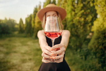 a glass of rose wine in the hands of a woman in close-up, photos in nature, winery