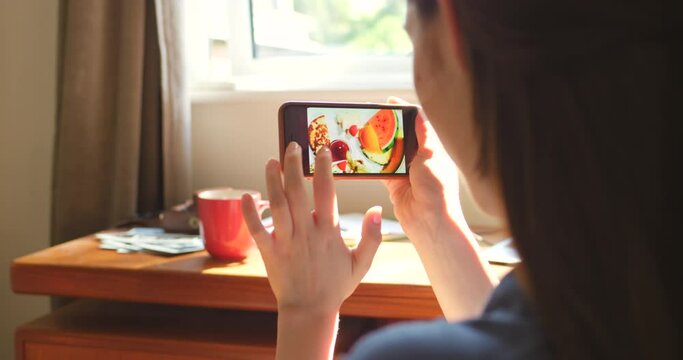 A woman looking at various photos on her smartphone