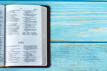 Joel open Holy Bible Book on a rustic wooden background with copy space. Top table view. Old...