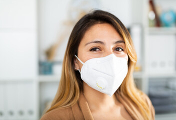 Portrait of businesswoman in disposable face mask in business office, new normal due to coronavirus...