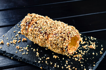 Trdelnik covered in nuts and sugar. Czech street food