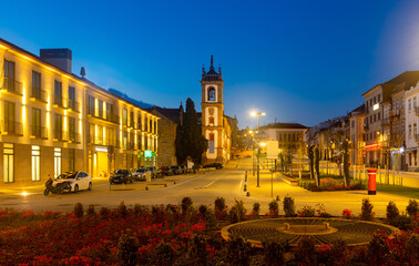Evening spring view of illuminated Carvalho Araujo Avenue with belfry of cathedral in central part of Vila Real, Portugal.