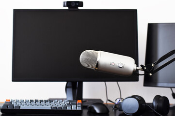 Large microphone on in front of computer screen on desk