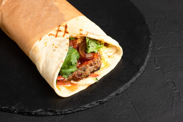 Burrito, Mexican beef burrito on a black background, side view
