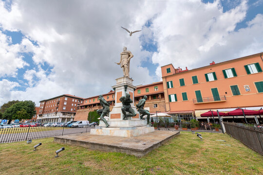 A seagull flies over the historic statue, Monument of the Four Moors which depicts the duke Ferdinand I with four Moorish slaves as reminder of Livorno's slave market, at the port of Livorno, Italy.