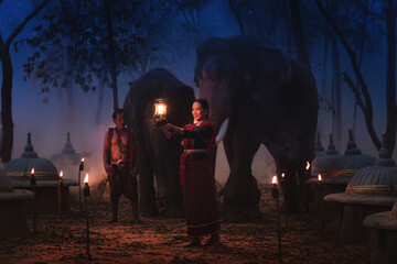 Thai tourist woman with elephant trainer and elephants at elephants cemetery in Thailand
