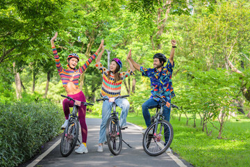 Transgender person with LGBTQ friends riding bicycle together in park