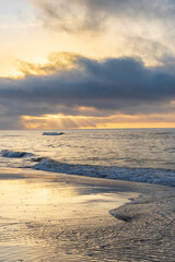 Sun rays coming through dark clouds on the waters of the Florida Gulf Coast shortly after dawn