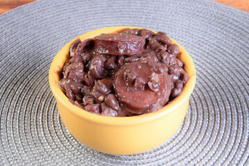 Feijoada typical Brazilian food, beans with pork bacon, orange rice and flour, chili sauce and crackling