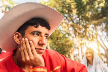 Latino teenager in love wearing traditional latinamerican clothes and hat outdoors in a park in Jinotega Nicaragua - obrazy, fototapety, plakaty