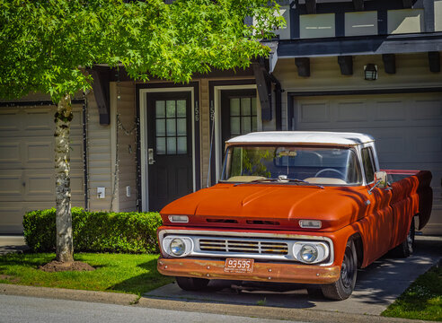 Retro pickup truck on a sunny summer day. Orange Chevrolet C10 Pick Up Truck. Vintage Chevy truck parked on a street