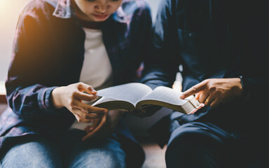 Christian couple or group reading study the bible together and pray at a home or Sunday school at...