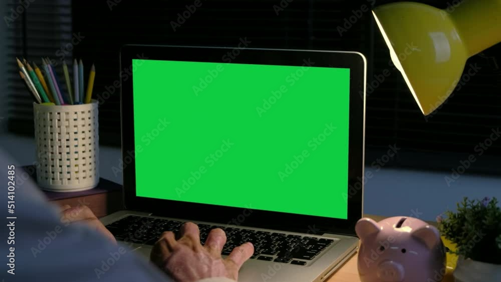 Poster back view of businessman hands typing and scrolling on a track pad with chroma key green screen lapt