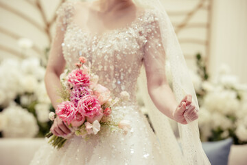 Bride holding wedding veil with bouquet