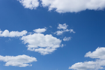 White clouds in a blue sky on a sunny summer day. Background, blank