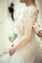 Bridesmaids fixing brides wedding dress
