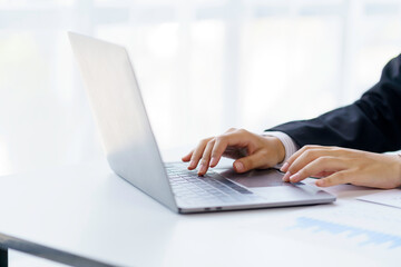 Close up of woman hand printing using laptop computer on the desk in the office.