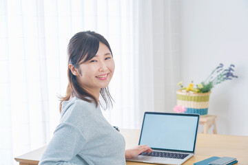 リビングでパソコンを使っている女性のポートレート