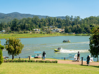 Nuwara Eliya, Sri Lanka - March 10, 2022: People walk in Gregory Park and go boating on the lake on a sunny day