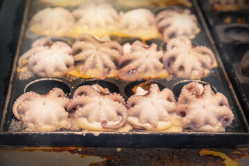 Japanese street food in Huahin Thailand. octopus baking balls in takoyaki pan at the night market.