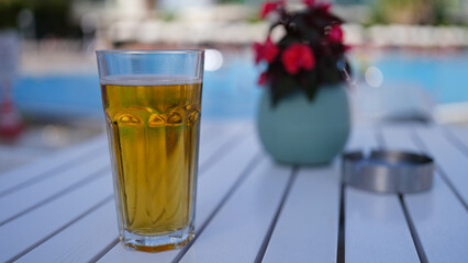 Glass of tea or beer on table in evening