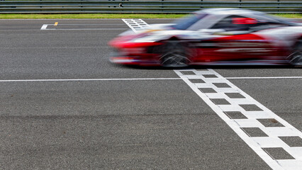 Race car blurred motion crossing the finish line on international circuit speed track, Motion blur...