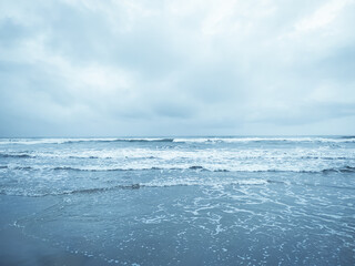 Naklejka na ściany i meble Blue ocean wave on the sea with cloudy sky background