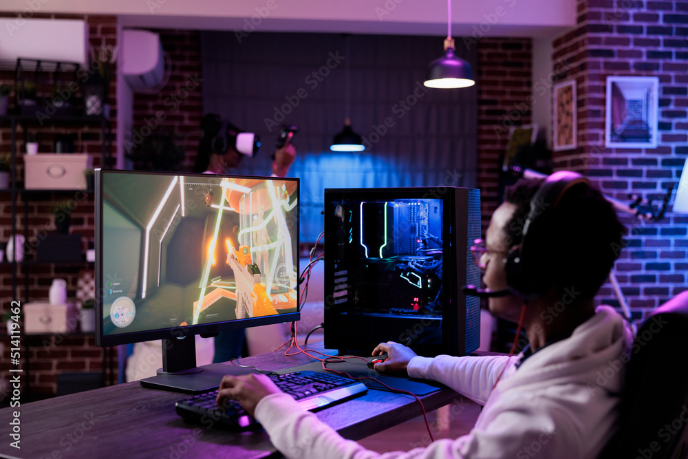 Wall mural male gamer playing video games competition online at computer station, enjoying live esport tourname