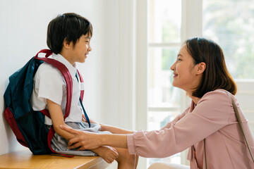 The mother prepares to send her son to school.