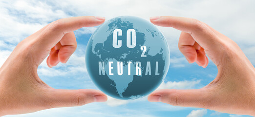 Carbon neutral concept. Hand holding CO2 neutral in globe map on blue sky and white clouds...