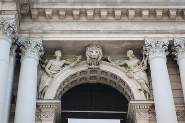 Sculptures of two muses with lyre and paper with pen as allegories of the arts. The head of a lion on the facade of the Opera and Ballet Theater in Lviv, Ukraine. Neo-Renaissance in architecture.